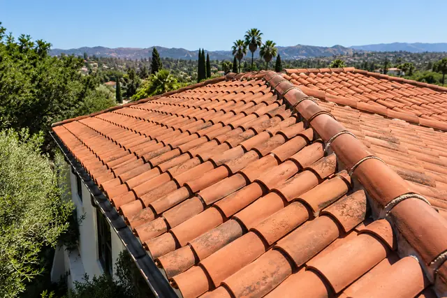 AI-generated illustration: clay tile roof on a Mediterranean home viewed from an elevated side angle